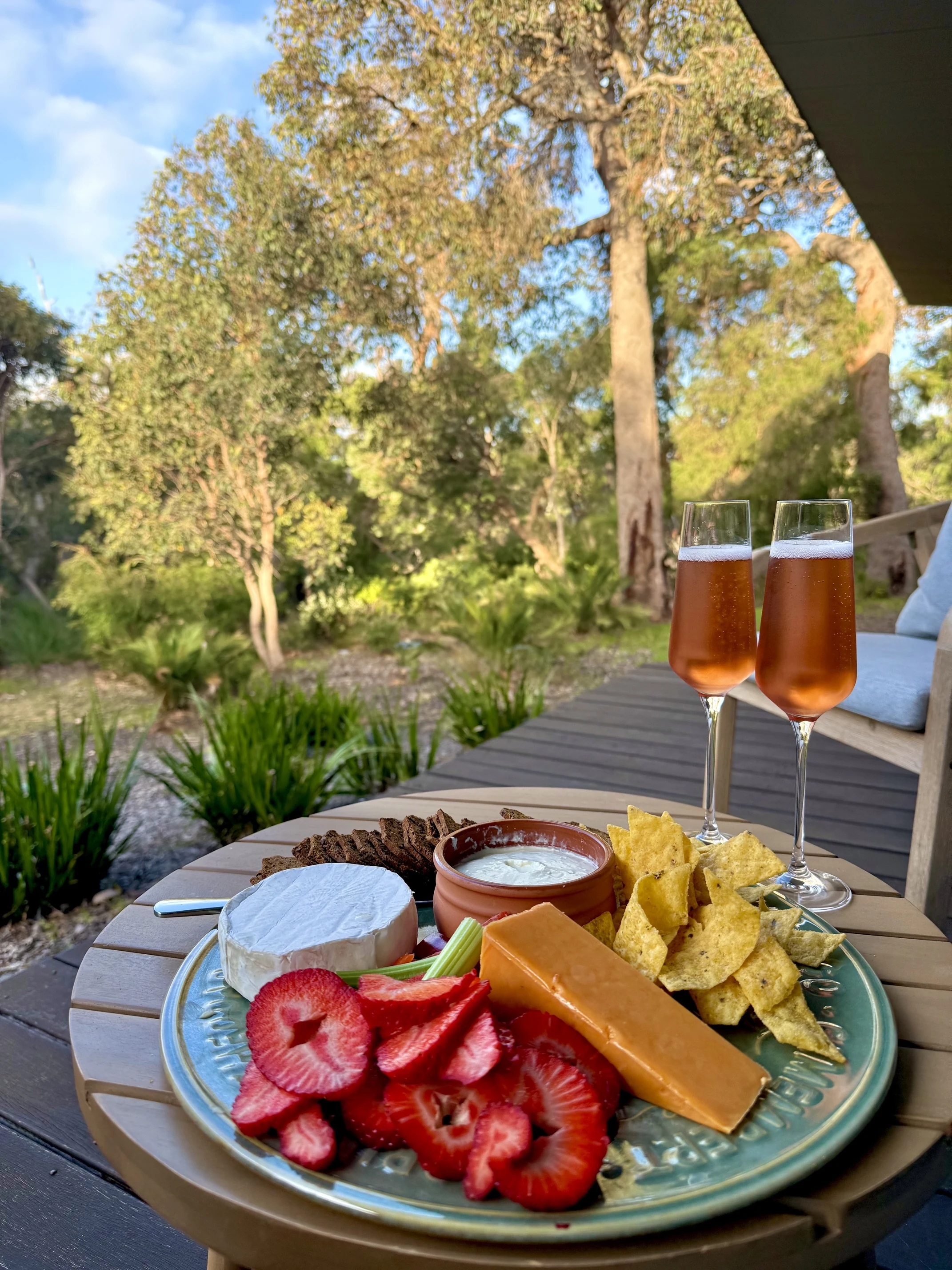 A drinks and cheese platter on the outdoor deck at Injidup Sanctuary, overlooking the private native bushland