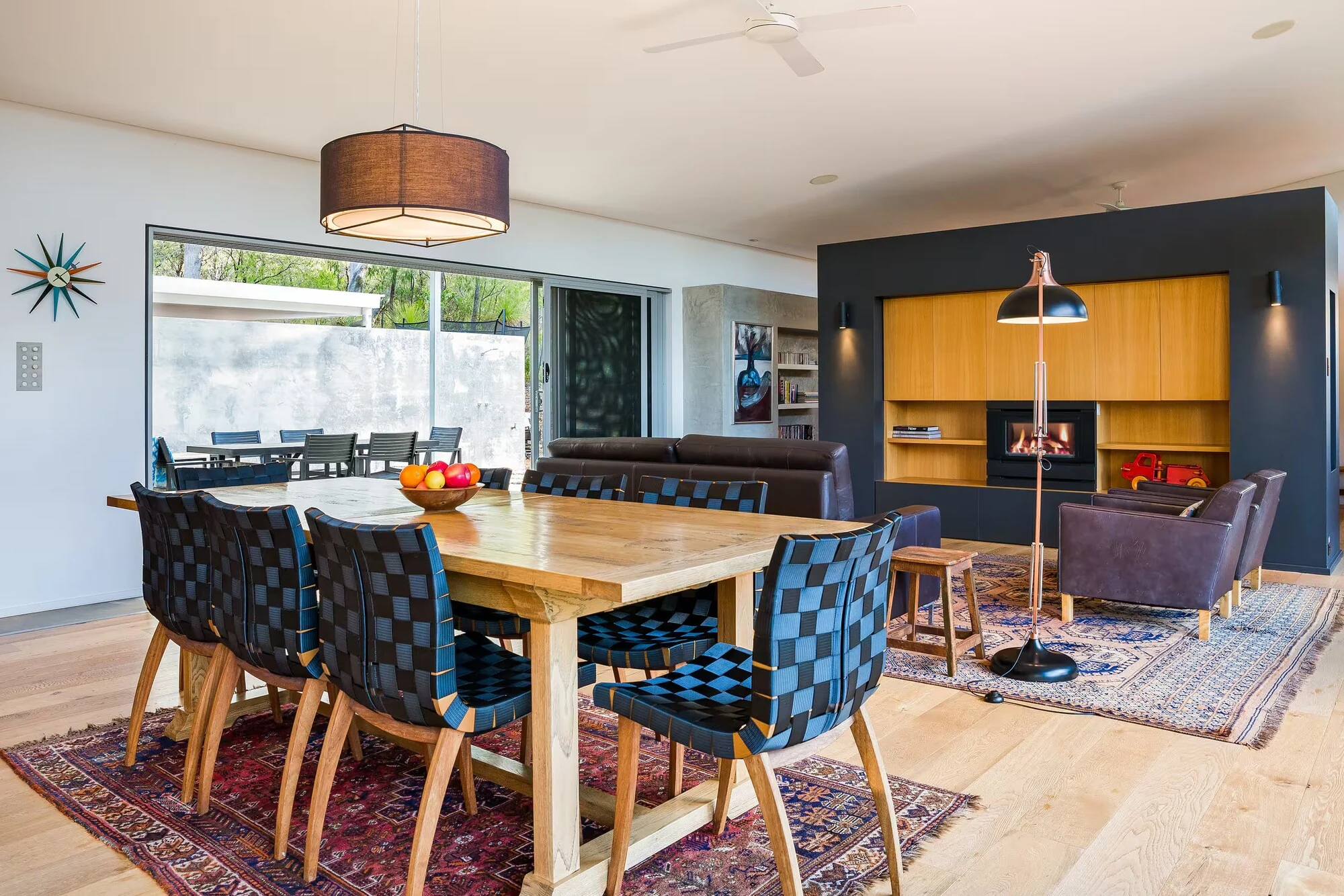 A wide view of Injidup Sanctuary's dining and lounge areas, with timber floors and original artworks