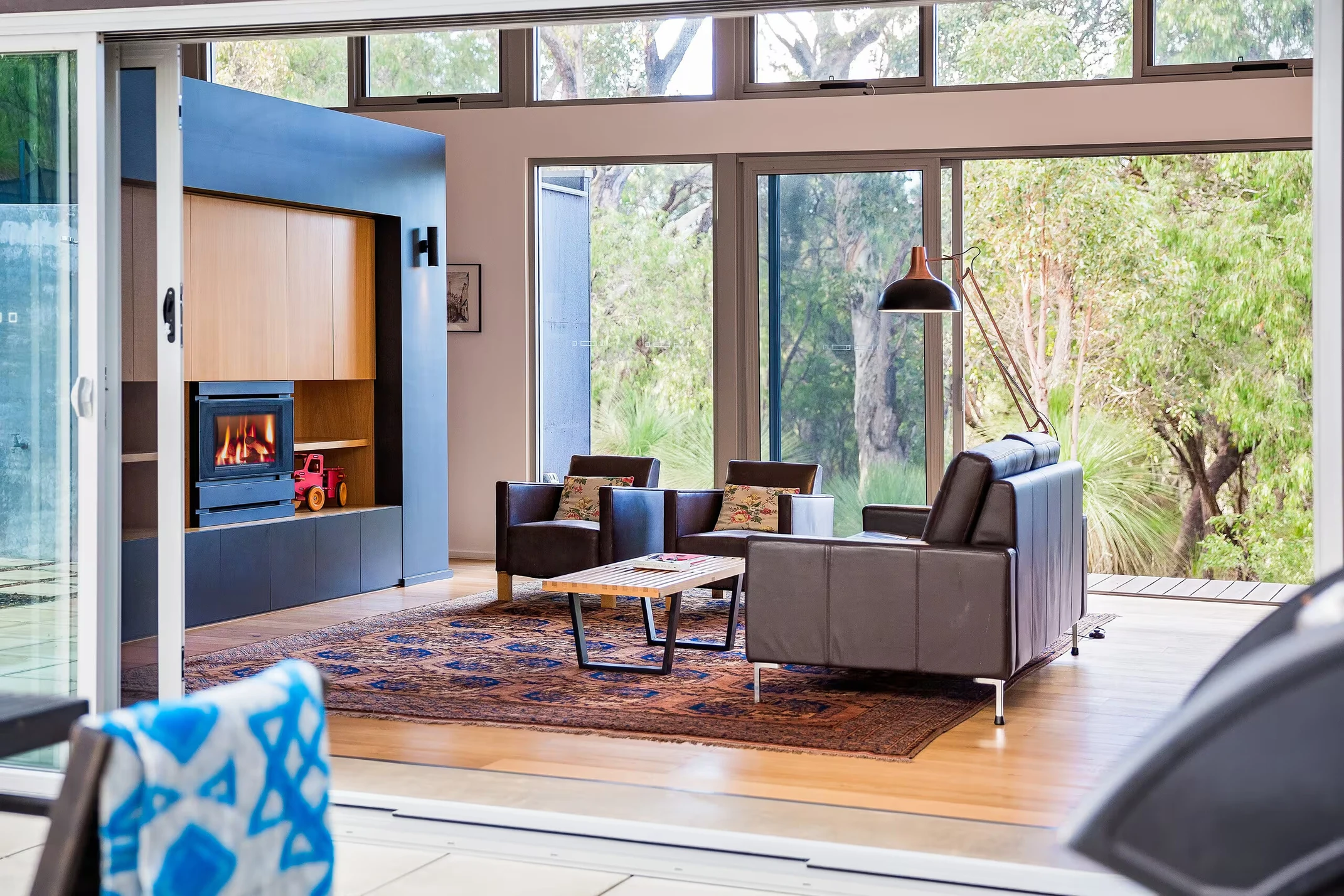 Injidup Sanctuary's lounge with armchairs, original artwork and floor-to-ceiling bushland views