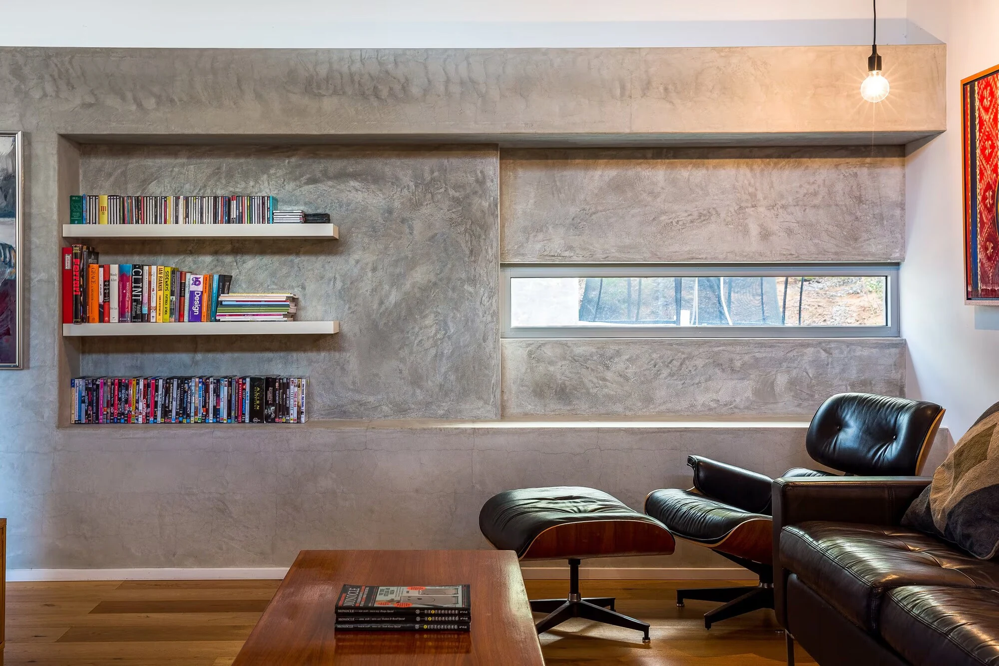 A quiet sitting area at Injidup Sanctuary with leather seating, bookshelves and a reading chair
